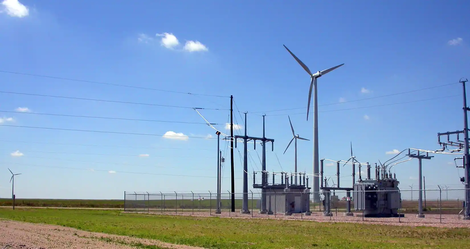 Electrical grid system next to wind turbines.