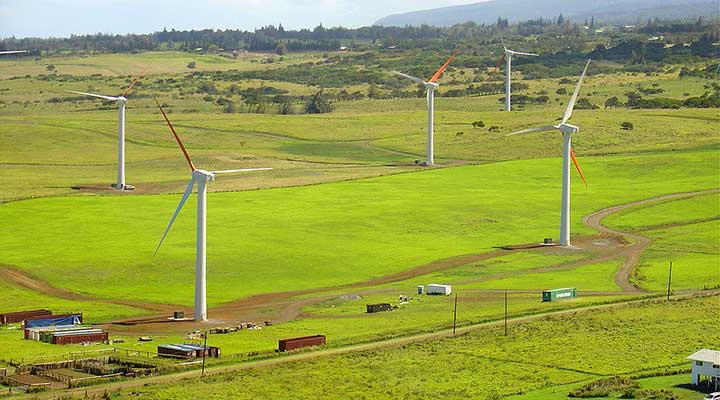 land-based-research-capability-energy-and-economic-analysis An aerial photo of five land-based wind turbines in a green field.