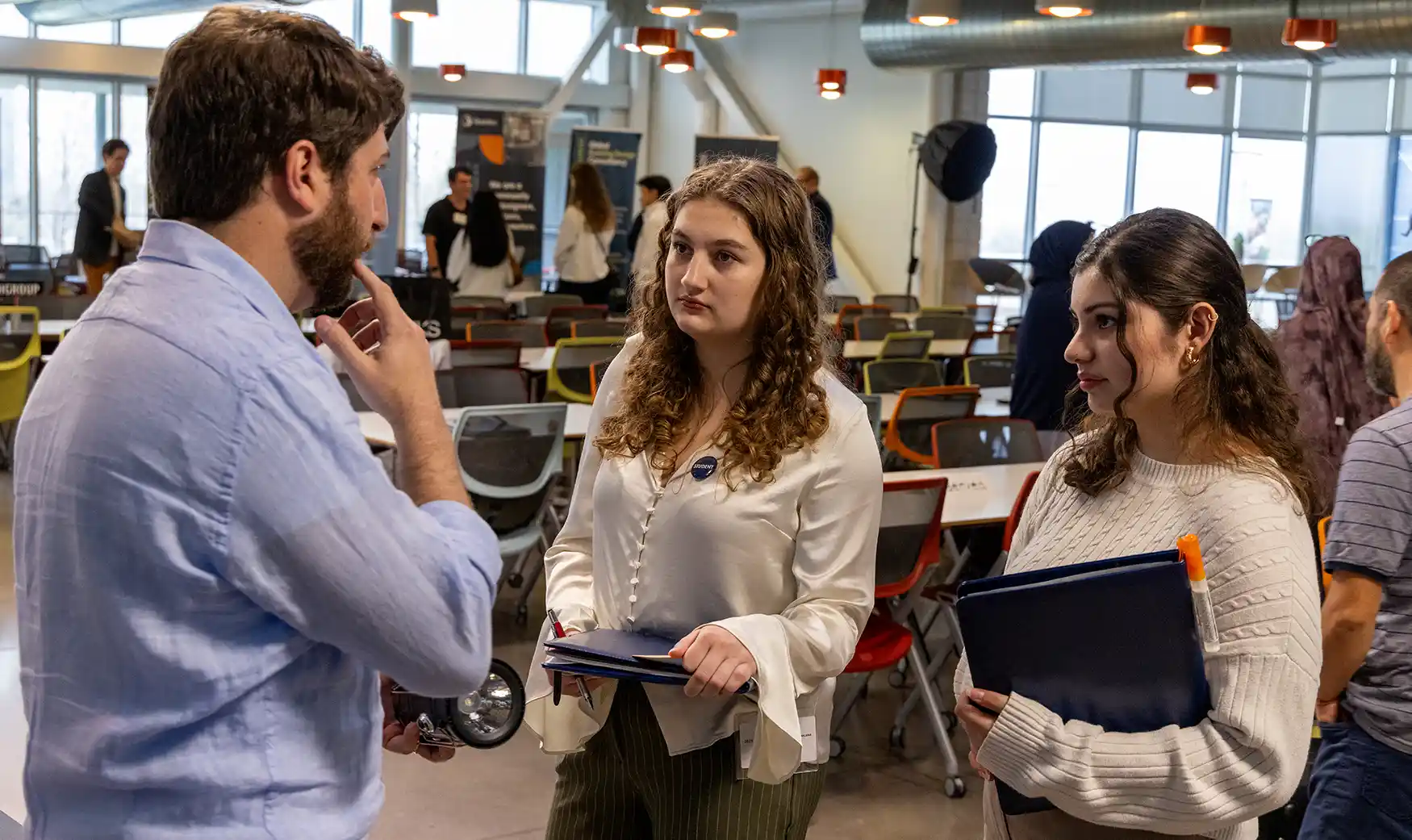 Two students talk to NLR researcher during network event.