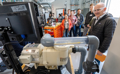 A group of people look at equipment in a lab
