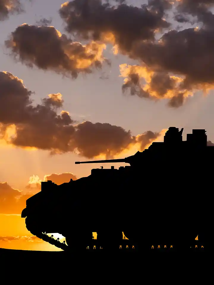 Silhouette of a military tank against a sunset