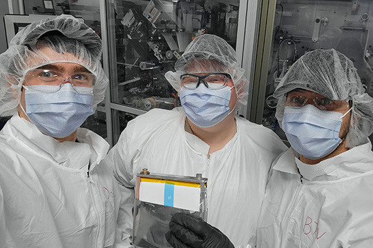 bat-man Three researchers wear face masks and plastic protective hair and body covers in a lab.