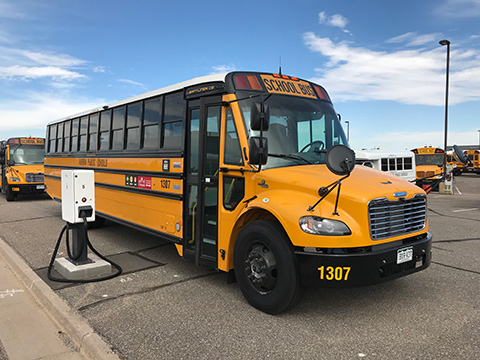 commercial-float-74748 An electric school bus next to a charging station