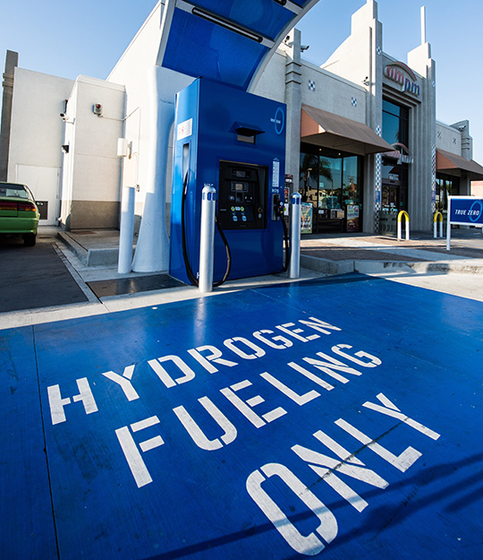 fall24-46428 A hydrogen fueling station with the ground painted blue and text painted on reading hydrogen fueling only.
