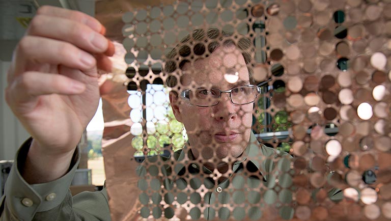 Photo of a researcher working with a plug flow reactor in a lab