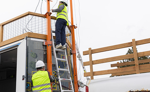 Two researchers adjusting IPC mobile lab equipment