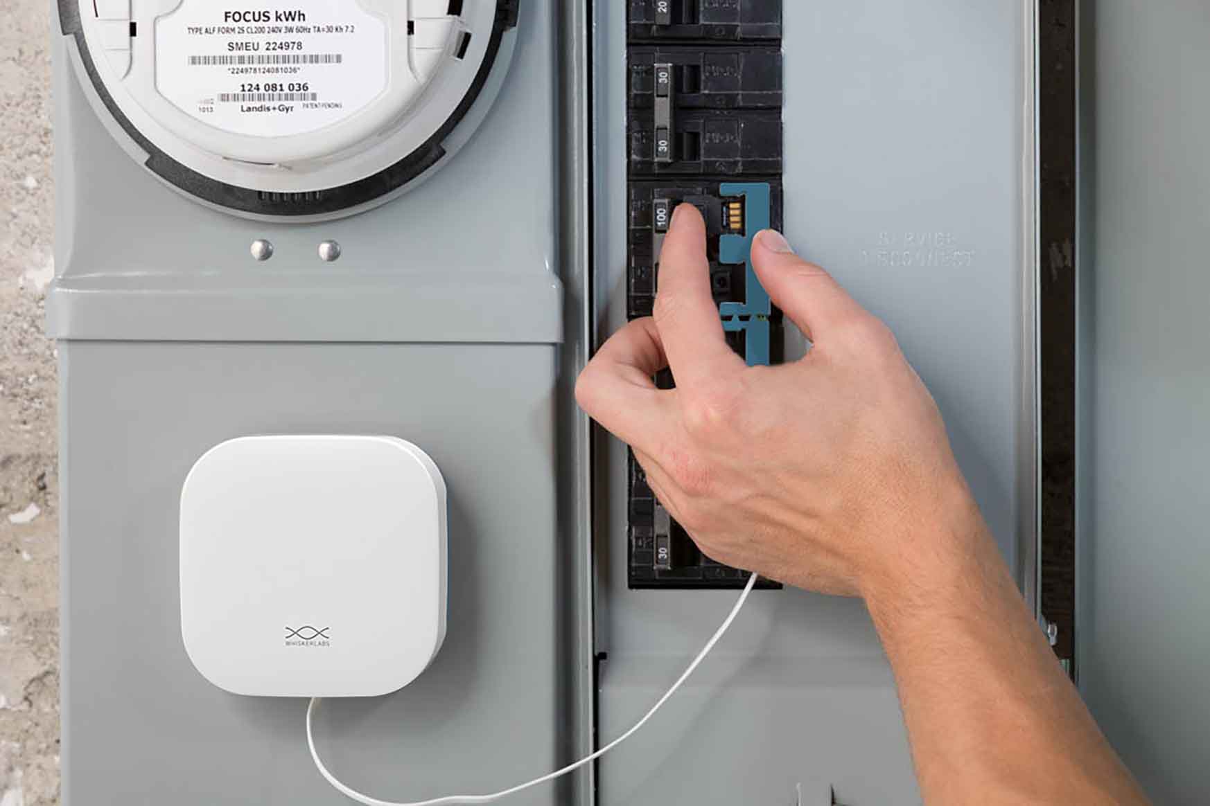 A close-up photo of hands attaching a wire to a circuit box.