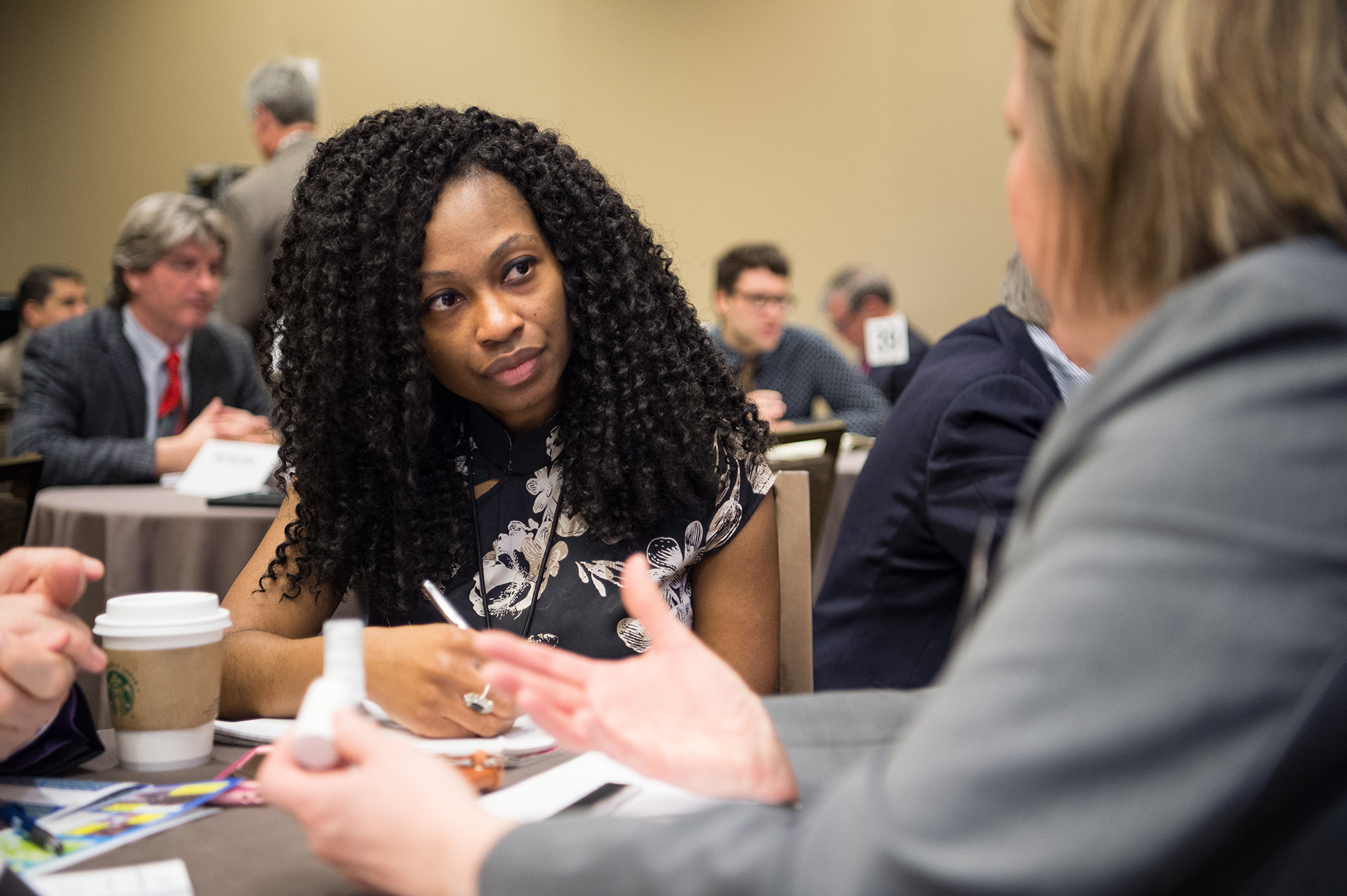 A photo of two women having a discussion at a table.