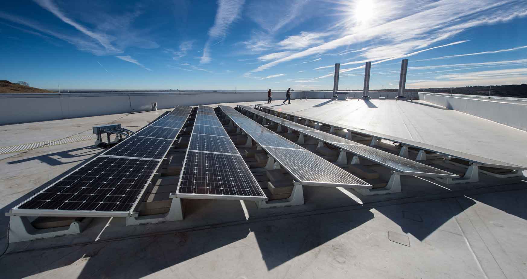 Photo of PV panels under a bright blue sky.