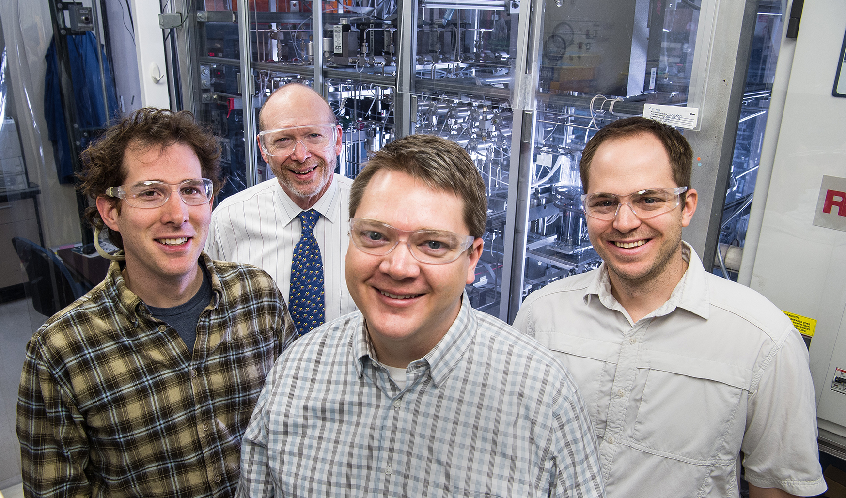 Four men stand in a laboratory at the National Renewable Energy Laboratory.