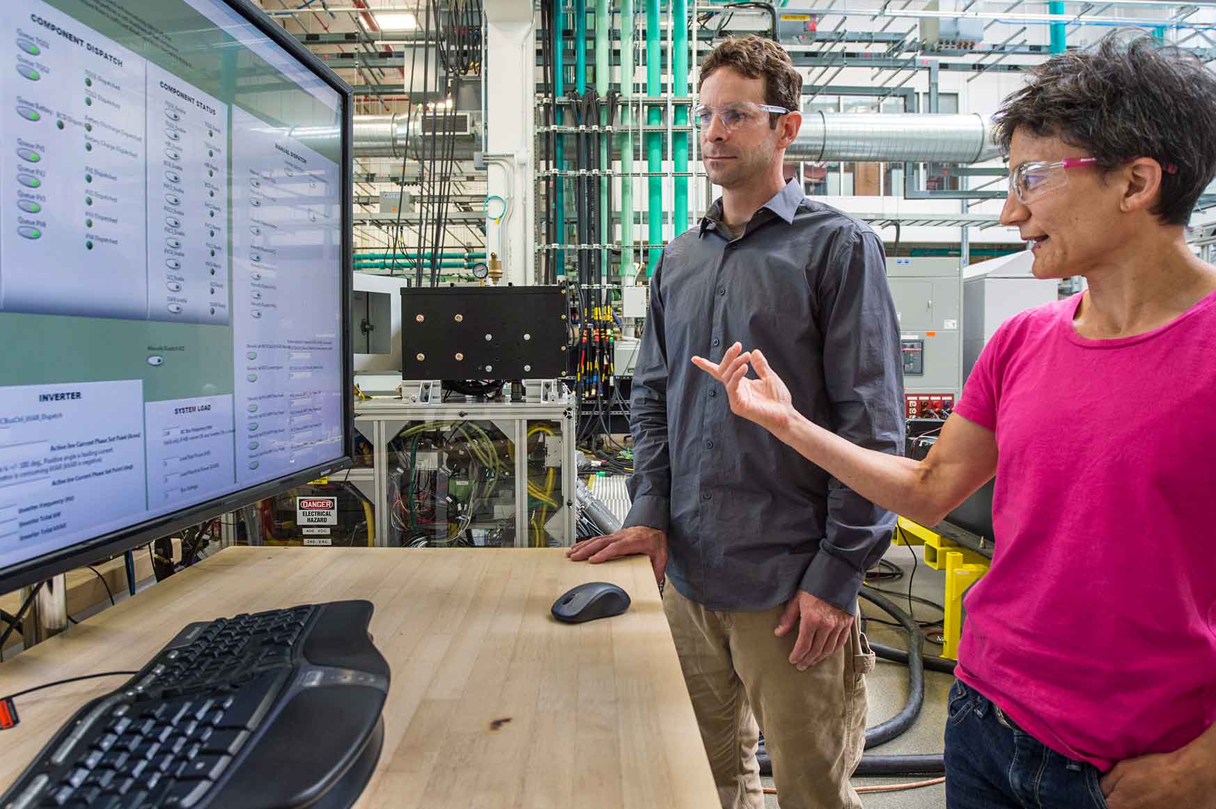 Two people study a computer screen that reveals data coming from the CUBE. 