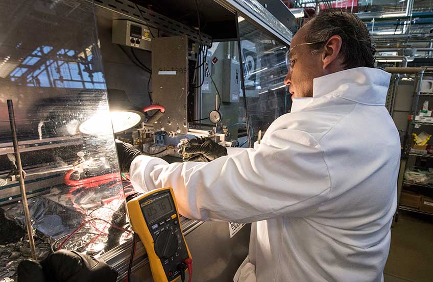 A man works with a piece of laboratory equipment.