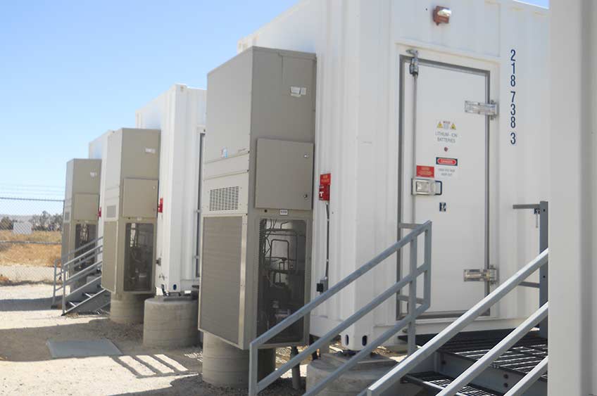 Photo of three large energy-storage units in a row outdoors.