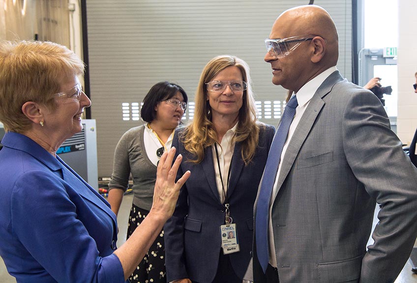 A woman talks to a man as two women stand nearby.