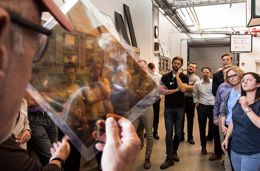 Man looking through a piece of process film in front of a group of students