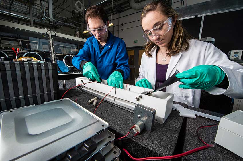 Two researchers looking over a chemical bath 