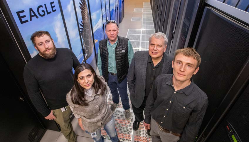 Group of people standing in front of a super computer