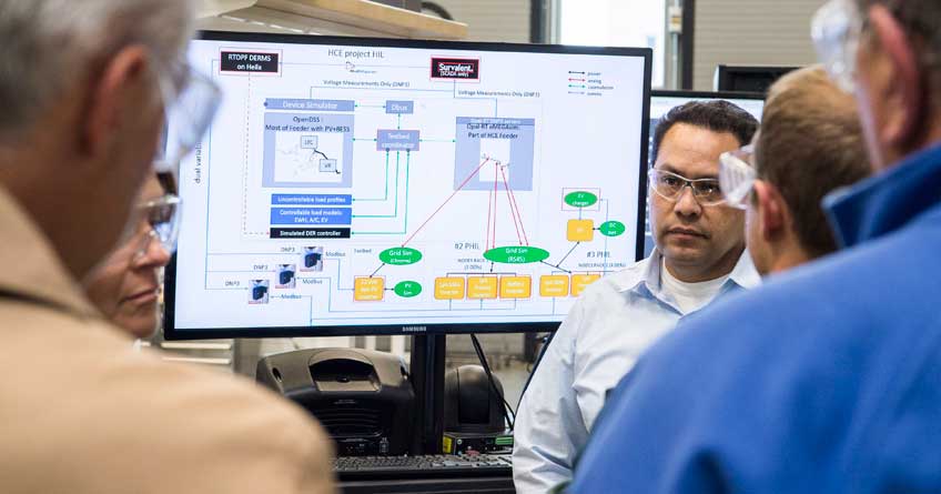 A man in a laboratory talks to a group.