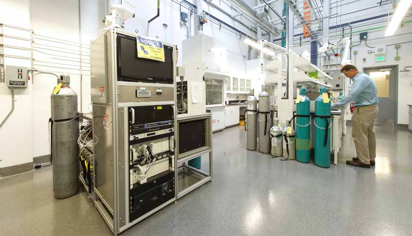 Photo of a man in a laboratory adjusting a piece of machinery.