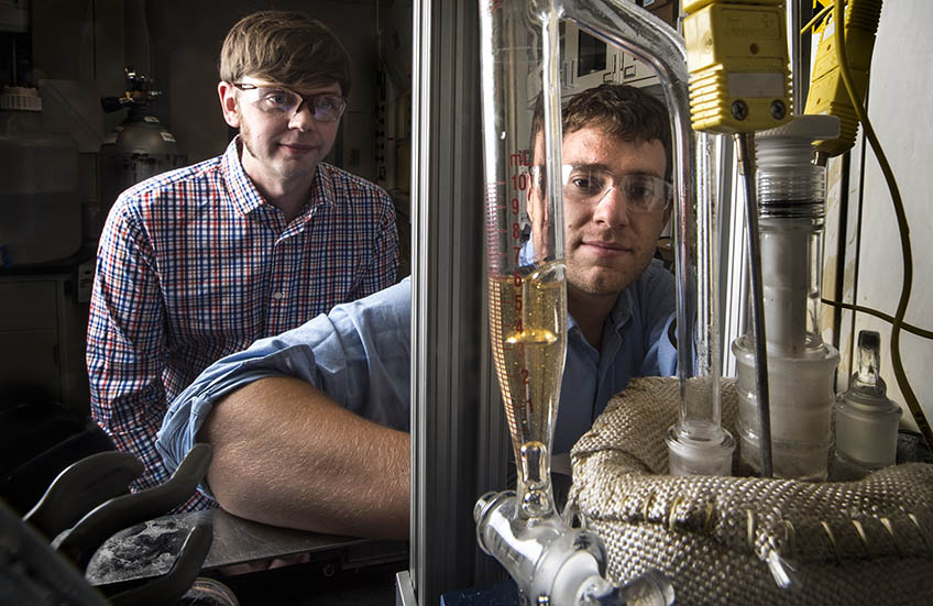 Two researchers working with scientific equipment in the lab.