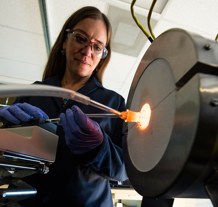 A woman works with laboratory equipment.