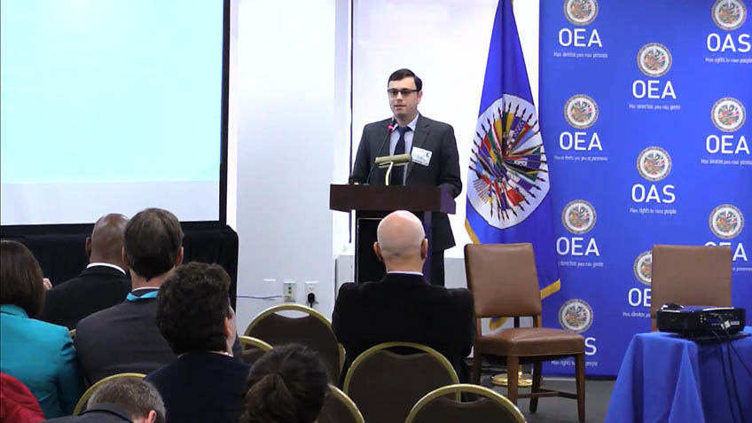 A man speaks to seated conference attendees.