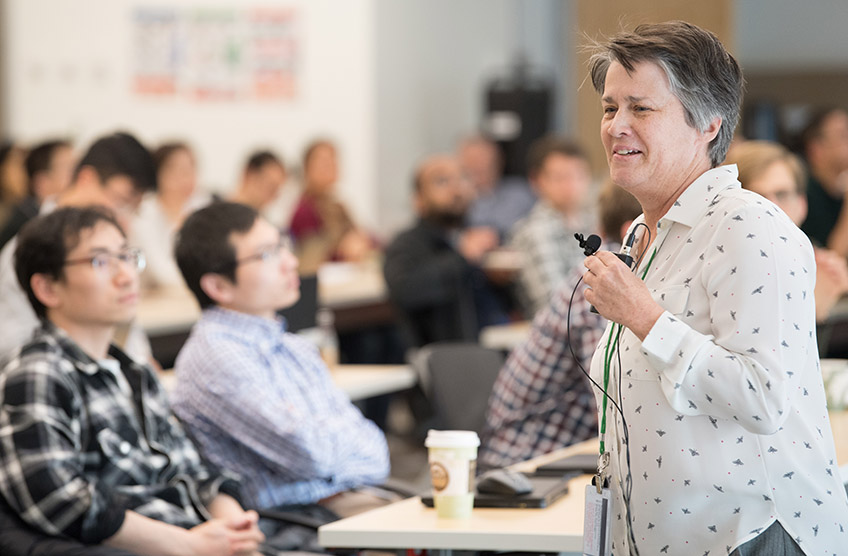 A woman speaks to an audience.