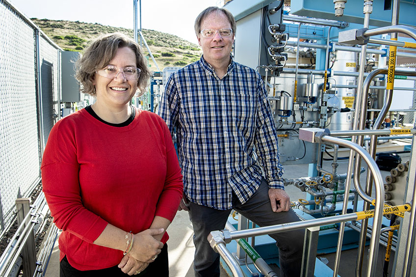 A woman and a man stand outside near NREL’s hydrogen compression and storage area.