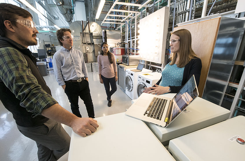 Four researchers talk in the lab