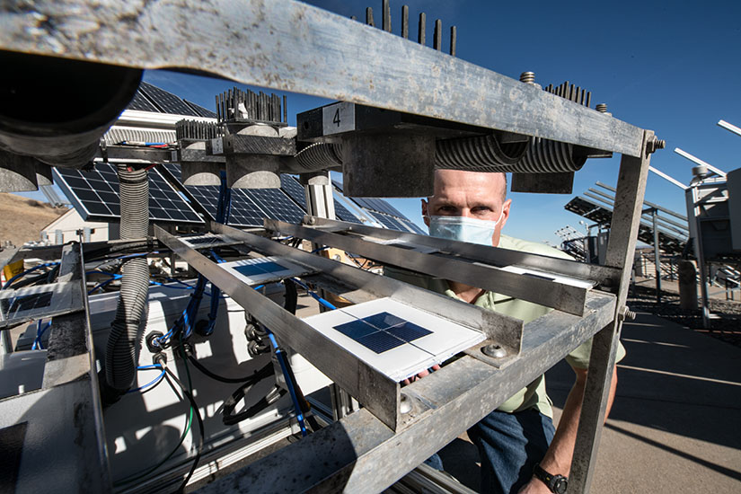 Видно, как мужчина просматривает набор датчиков, предназначенных для измерения загрязнения солнечных батарей.
