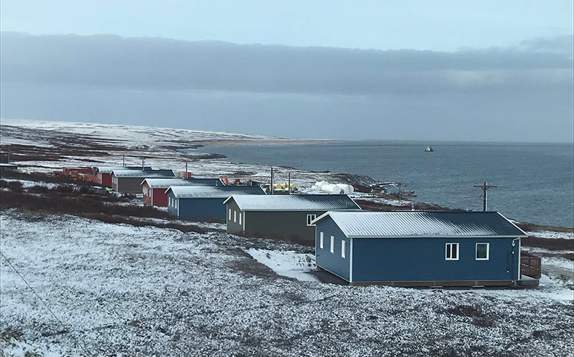 Photo of a row of houses near an Arctic coastline