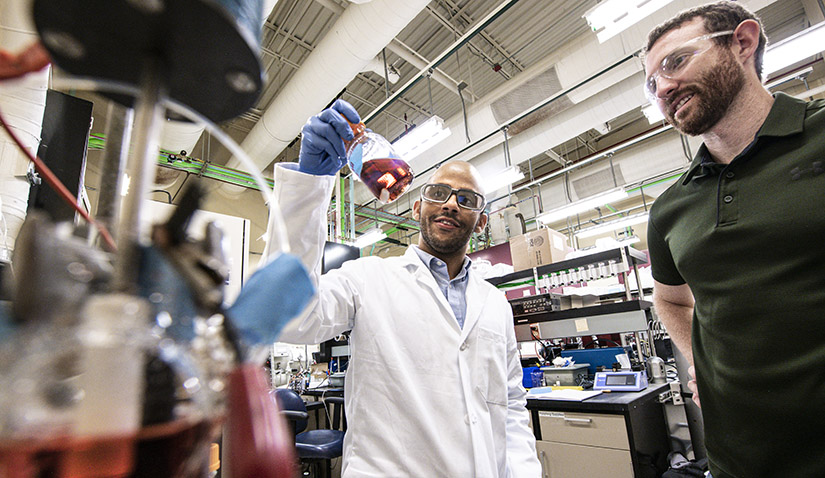 Photo of two men talking in a science lab