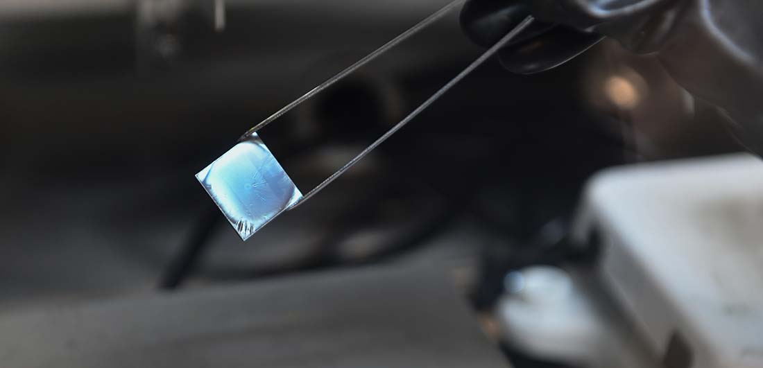 A perovskite sample held by a pair of tweezers