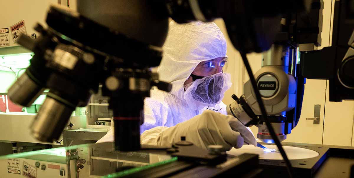 A scientist looking at a microscope