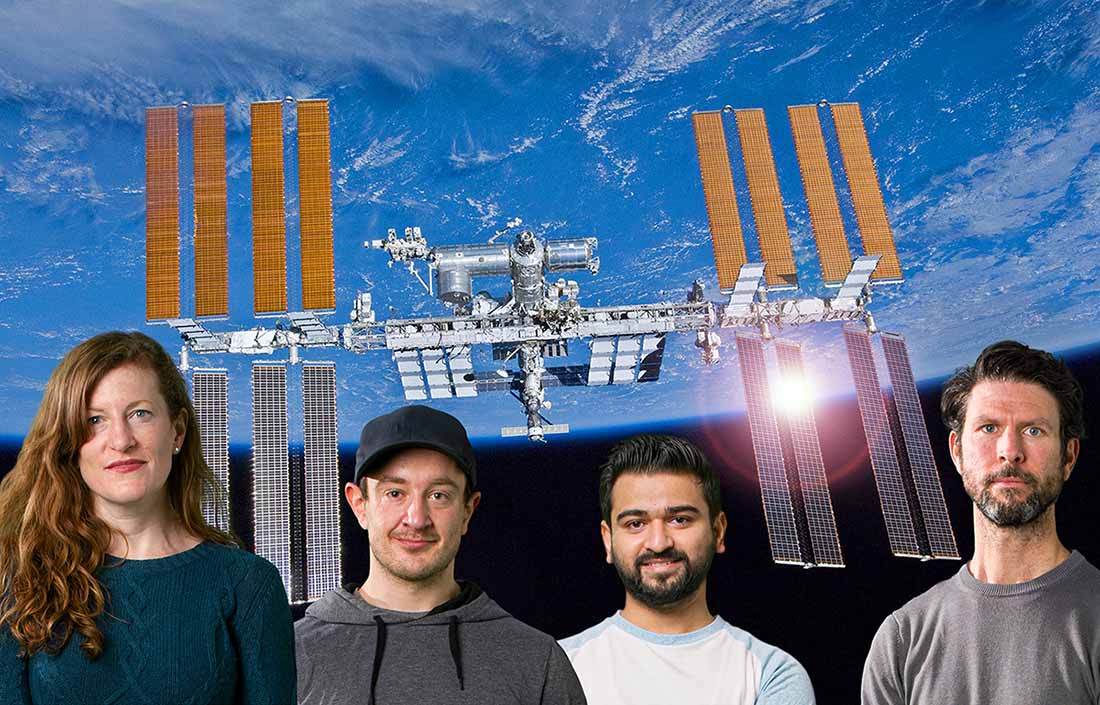 Four scientists standing in front of an image of the International Space Station