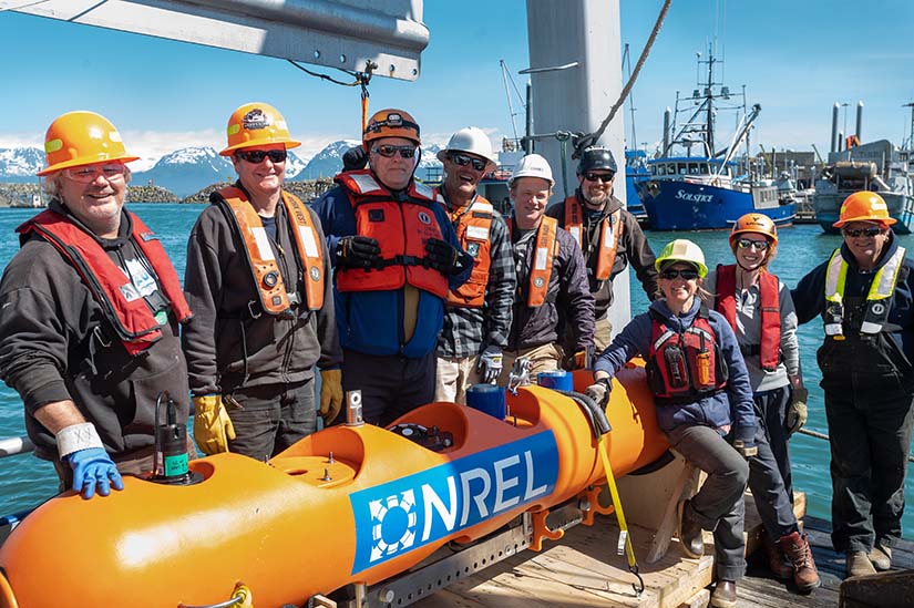 Group of people in front of an orange buoy