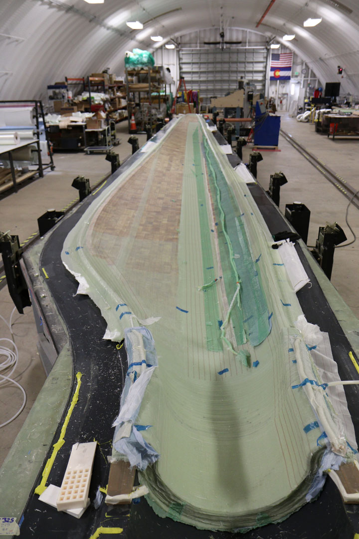 Photo of a large thermoplastic wind turbine blade in a mold.