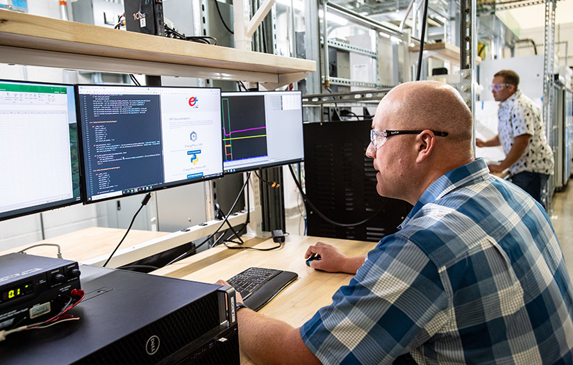 Photo of two people working at computers in a lab