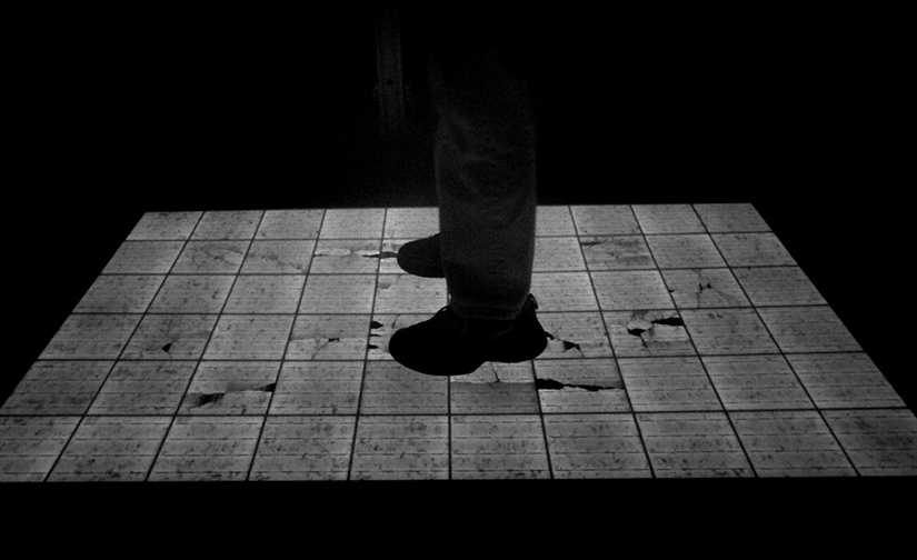 Photo of a person's feet standing on cracking solar modules