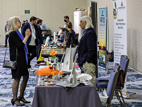 Two people speaking at a table in an exhibition hall