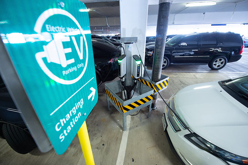 Photo of electric vehicles connected to chargers in a parking garage