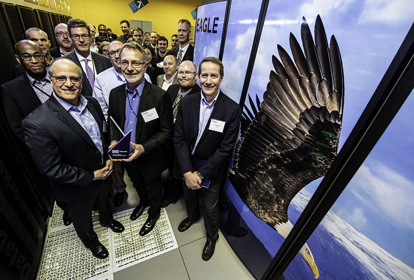 A group of people stand next to the "Eagle" supercomputer