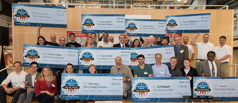 People on stage holding large checks.