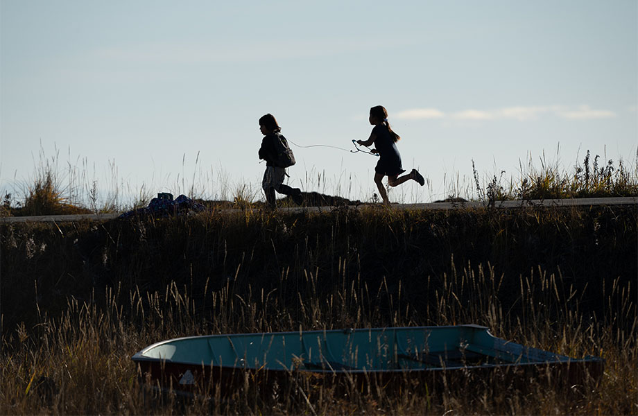 Village kids silhouetted against a beach