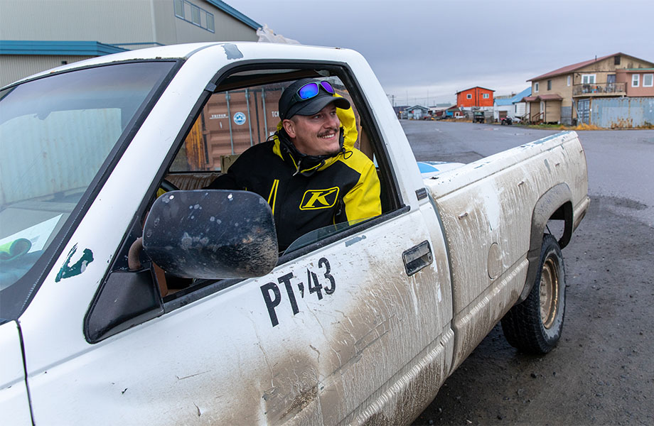 A man in a truck, smiling through an open window