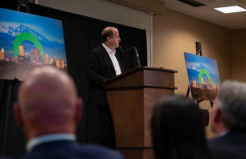 A man stands at a podium in front of a room of people.