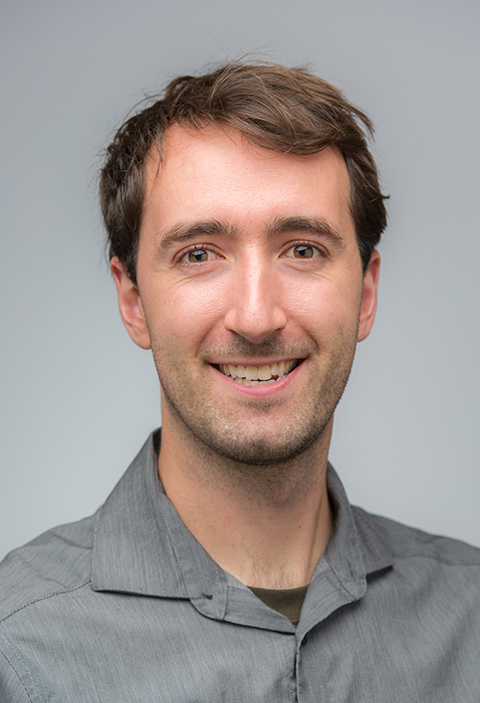 Headshot photo of a smiling man