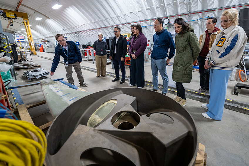 A group of people examine industrial materials.