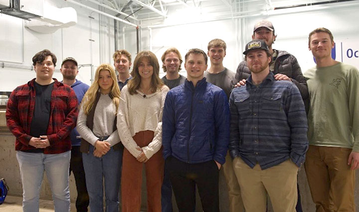 A team of eleven students pose for an photo indoors