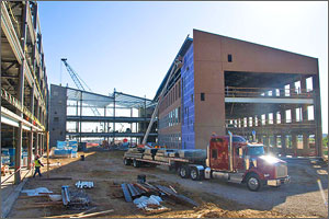 Photo of a truck delivering materials to an office building under construction.
